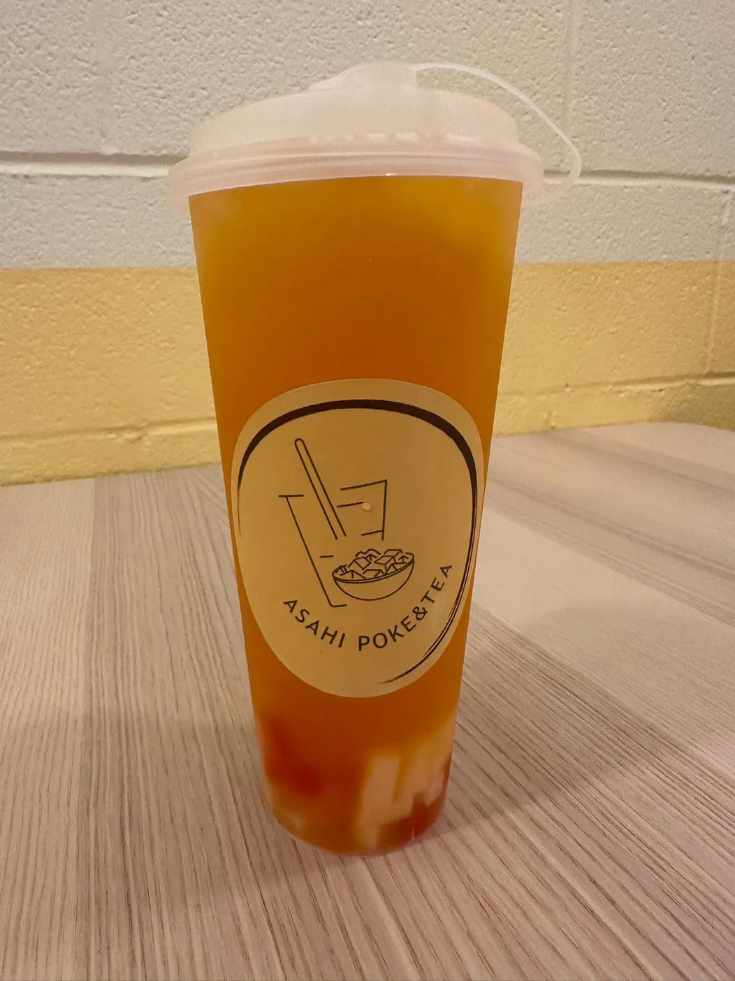 Tall orange fruit tea in branded Asahi Poke & Tea cup with visible toppings at Asahi Poke & Tea, a Bubble tea store in Beacon